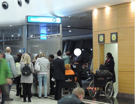 The tall white man and Checkport employees at a boarding gate of SAA flying from Johannesburg to Frankfurt, 2017. © O.K.