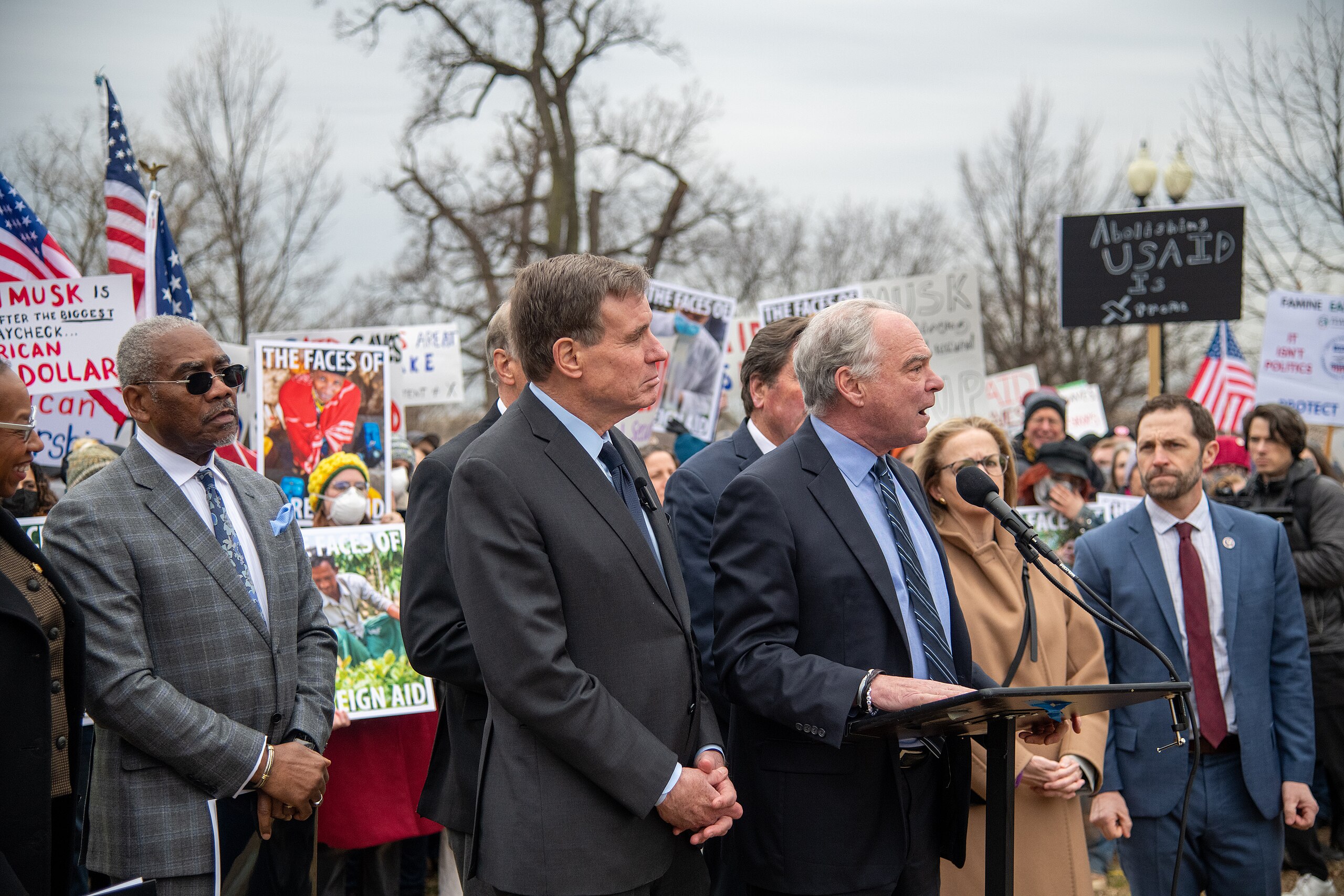 2. USAID, Source: Senator Mark Warner, https://commons.wikimedia.org/wiki/File:Senator_Mark_Warner_stands_with_United_States_Agency_for_International_Development_(USAID)_workers_on_5_February_2025_-_1.jpg